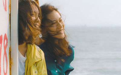 Deux jeunes femmes sourient face à la mer dans une scène du film Out of Place.