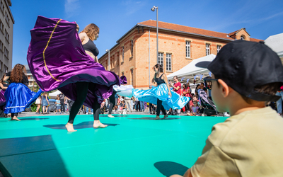 enfant de dos au 1er plan avec casquette et lunettes noires regardant une démonstrastion de danse flamenco