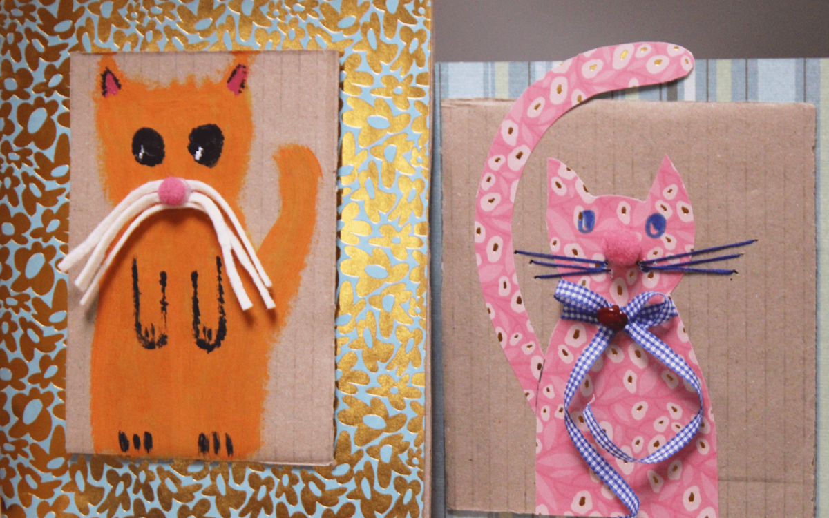 Deux cadres décorés avec du papier à motif et de la peinture. Dans les deux cadres, il y a deux chats orange et rose dessinés à la main. 