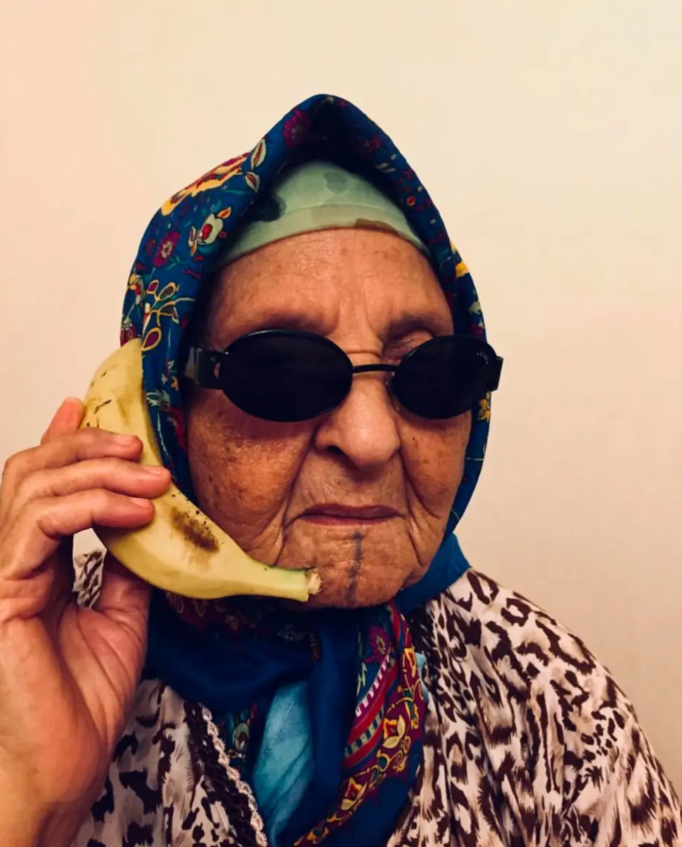 Affiche Food Temple Maroc représentant une vieille dame avec une banane sur l'oreille en guise de téléphone.