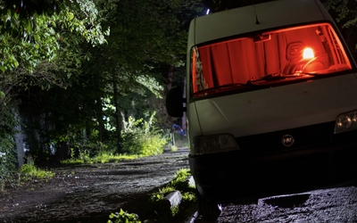 camionnette blanche garée dans le bois de Boulogne, avec une lumière rouge à l'intérieur au niveau du siège conducteur