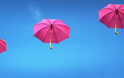 Parapluies roses flottant dans le ciel bleu