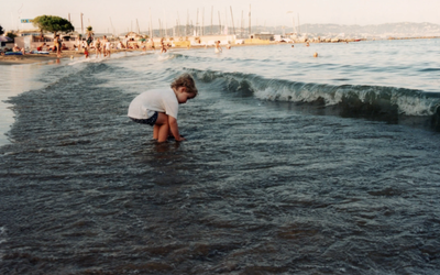 Image d'archive issue du film COMME UNE PIEUVRE : un enfant joue dans les vagues au bord d'une plage