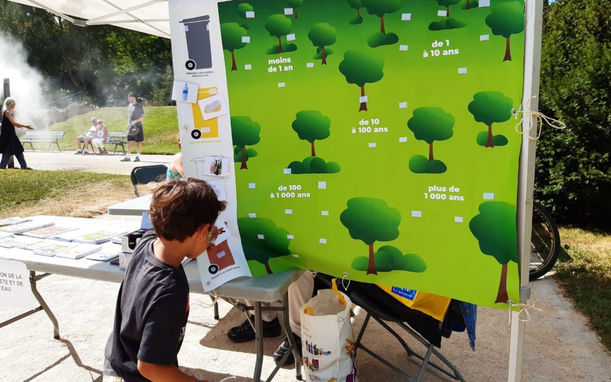 Un enfant participe à un atelier de sensibilisation au temps de dégradation des déchets.