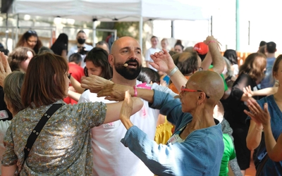 Johan Amselem guide un groupe de participant·es lors d’un bal participatif en plein air. Les personnes, de tous âges et horizons, dansent ensemble au Bassin de la Villette à Paris dans une ambiance festive et inclusive.