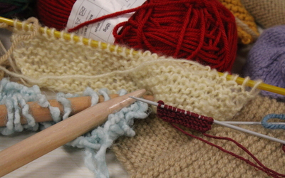 Photographie de matériels de tricot : aiguilles, laine, mailes etc. prise lors d'un atelier.