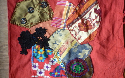 Photographie d'un tote-bag sur lequel ont été cousus aléatoirement des patchs de différents motifs et coloris.