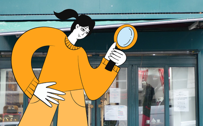 Photographie de la devanture de La Ressourcerie Créative avec un dessin de femme en train de tenir une loupe.