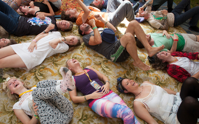 Des personnes installées au sol en pleine séance de yoga du rire.
