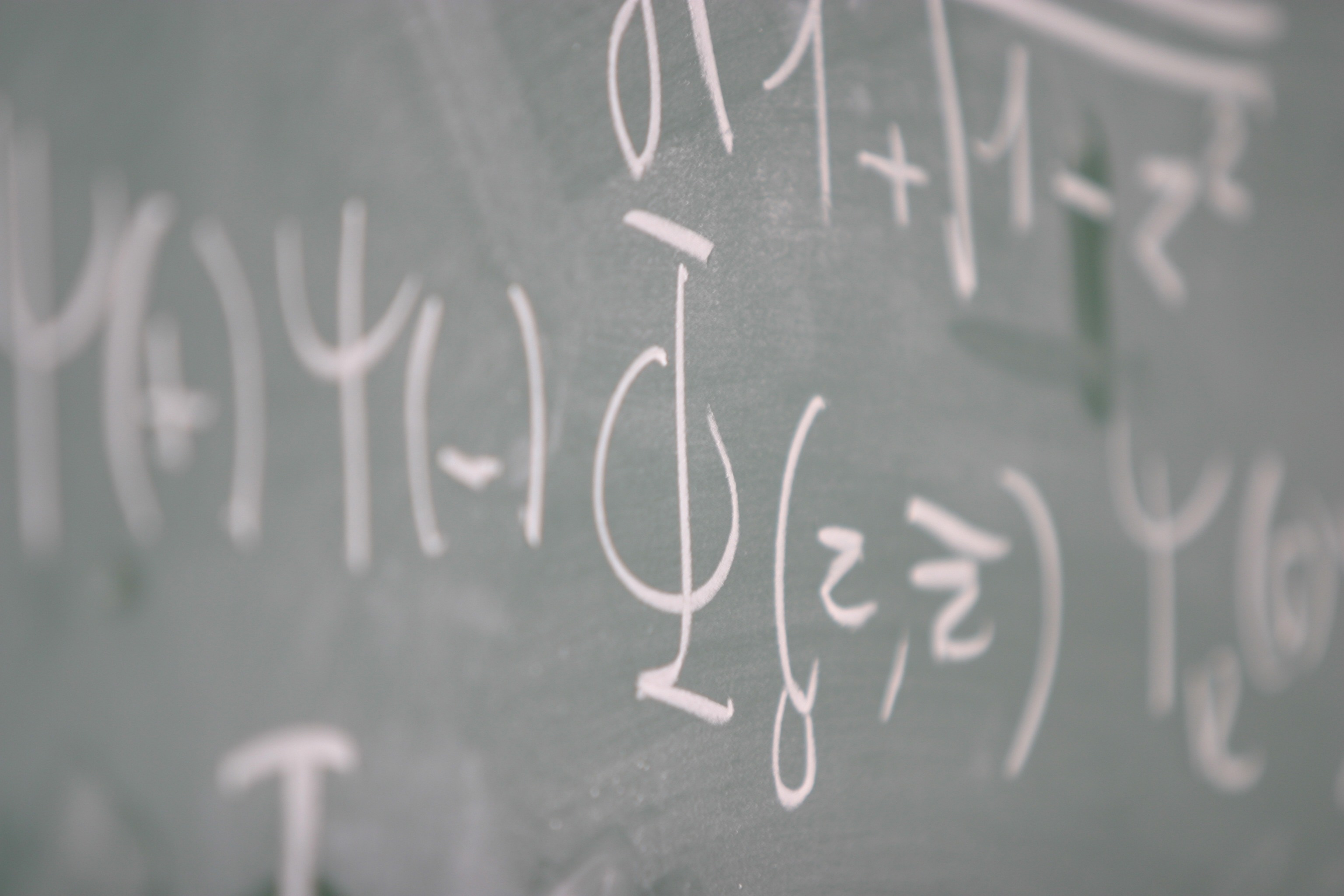 symboles mathématiques à la craie blanche sur un tableau noir