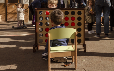 Enfant vue de dos jouant à un jeu géant de puissance 4