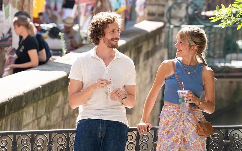 une femme et un homme prenant un verre sur un pont