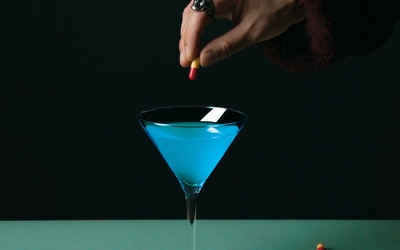 Affiche représentant une main verser des pilules dans un verre à cocktail