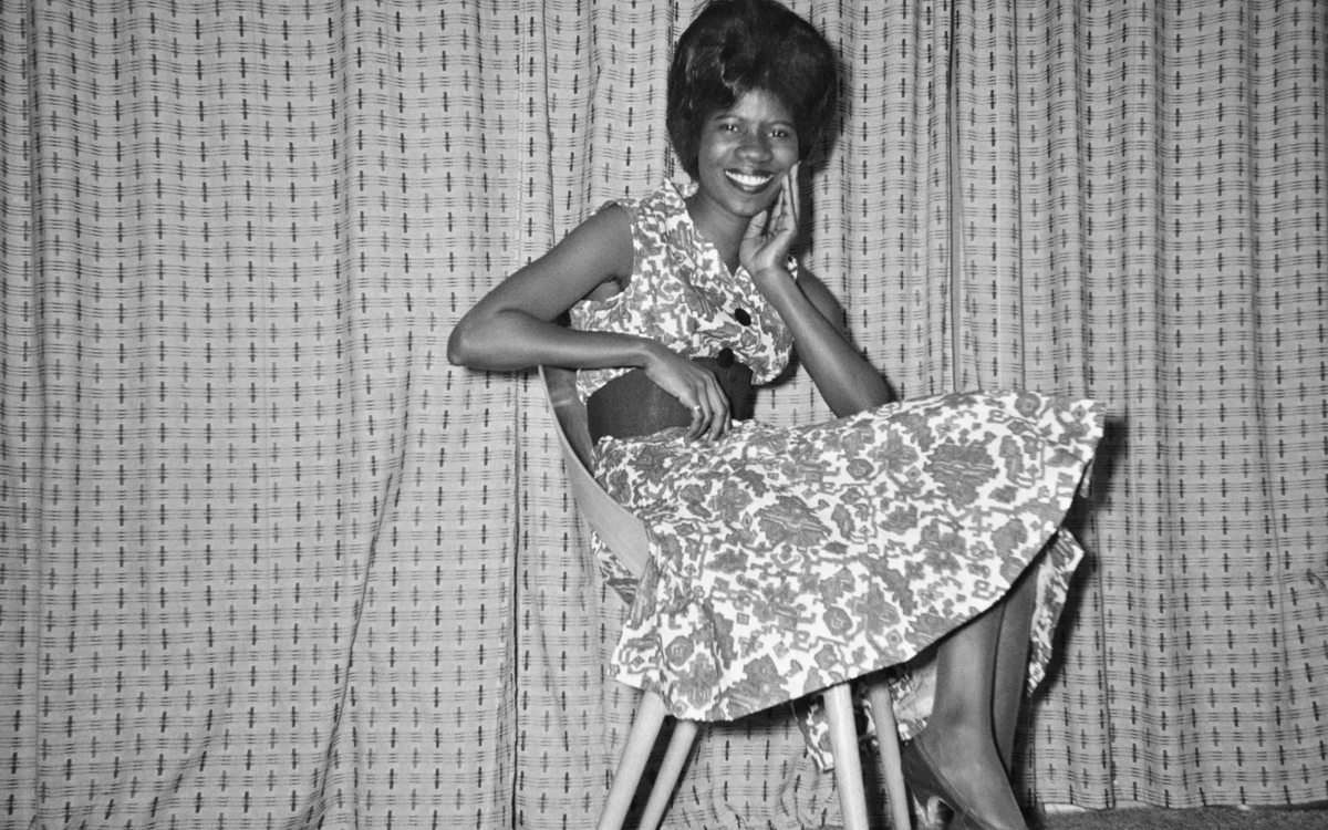 Photographie en noir et blanc de James Barnor représentant une femme assise sur une chaise